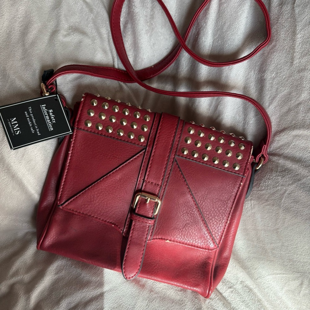 Red crossbody purse with gold studs and buckle detail